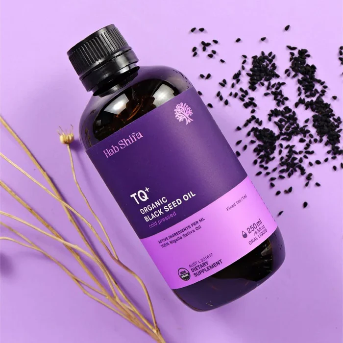 Black cumin (Nigella sativa) seeds and oil on a bright kitchen surface